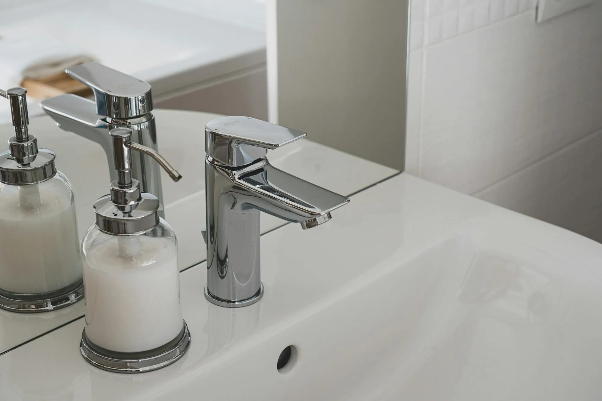 Chrome bathroom basin tap on a white ceramic basin