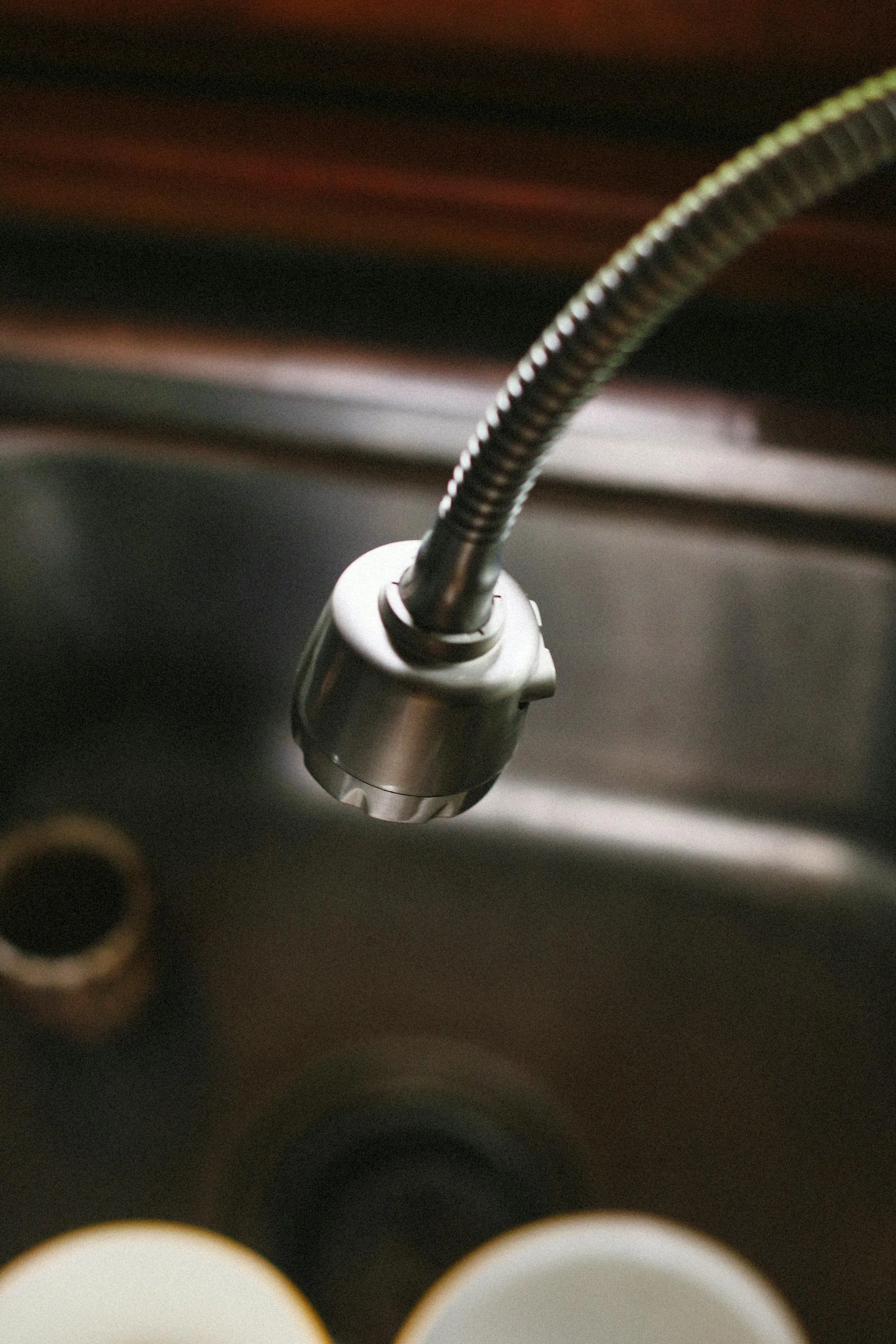 Chrome pull-down kitchen tap over a stainless steel sink